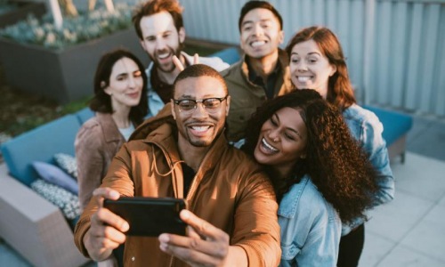 Group of friends taking a group selfie outdoors