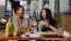 A couple of women eating burgers at a restaurant